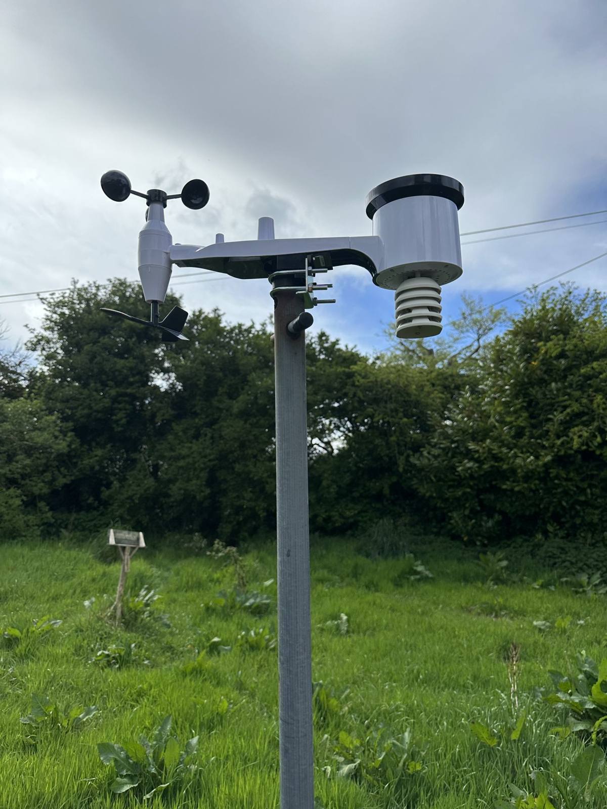 A weather station instrument against a stormy sky